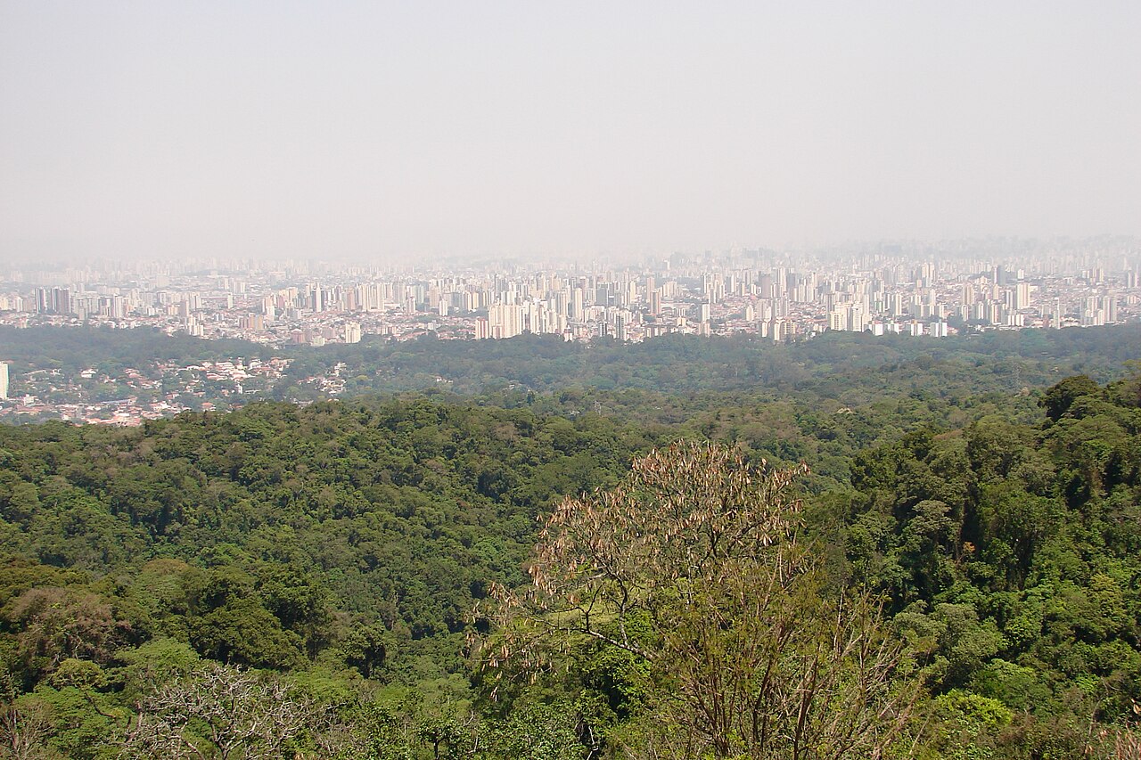 Portão de entrada com letreiro Parque da Cantareira - Núcleo Pedra Grande, guarita à direita e árvores ao redor.