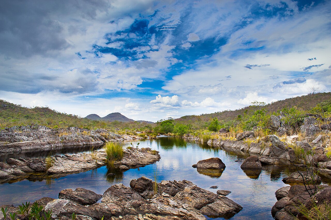 Rio entre pedras e vegetação.