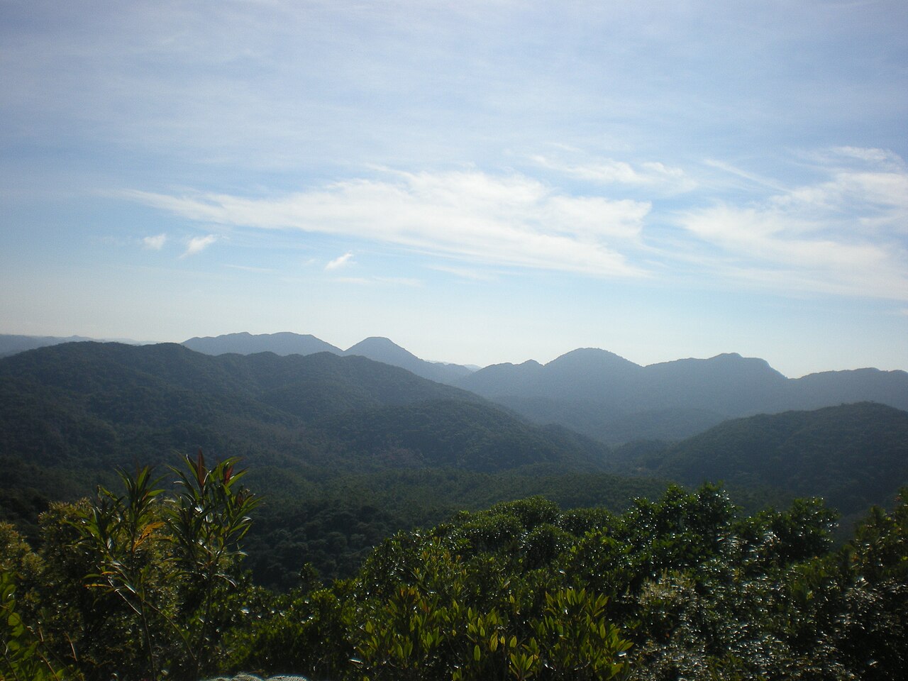 Vista aberta de morros e vegetação.