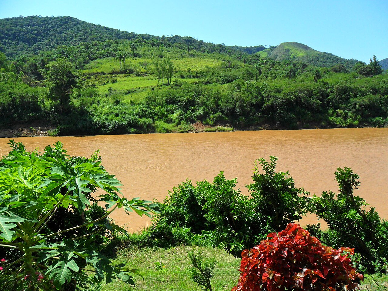 Rio entre pedras e vegetação.