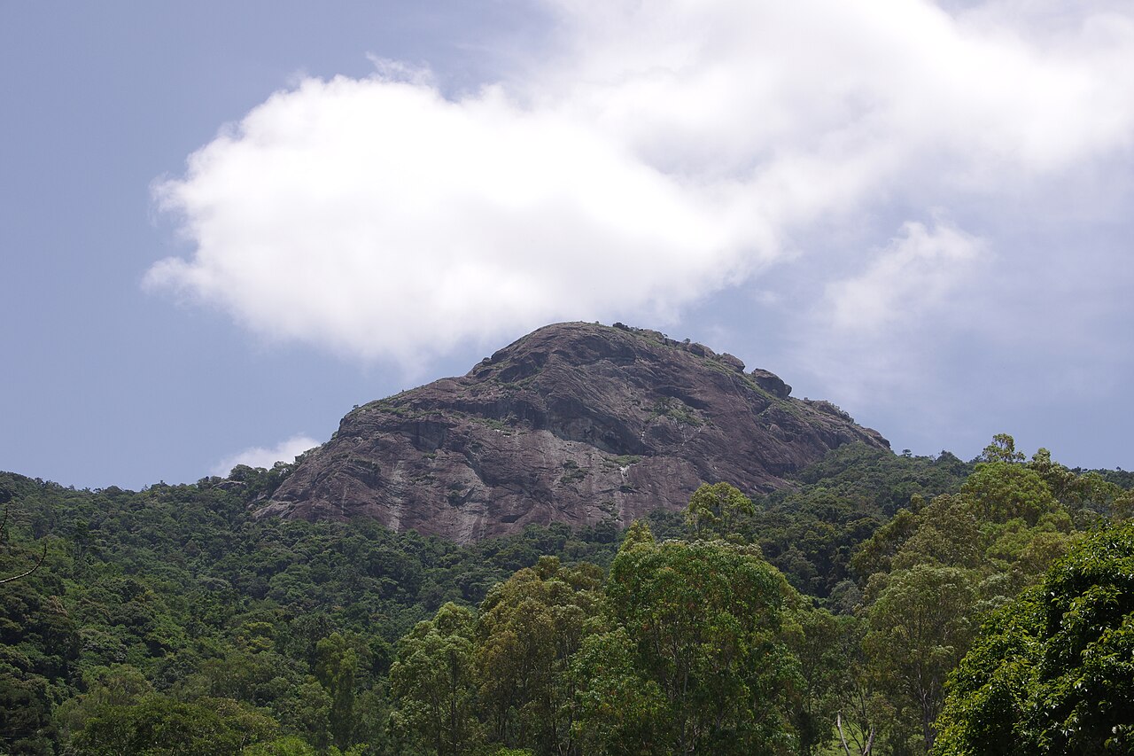 Paredão rochoso da Pedra do Baú entre morros.