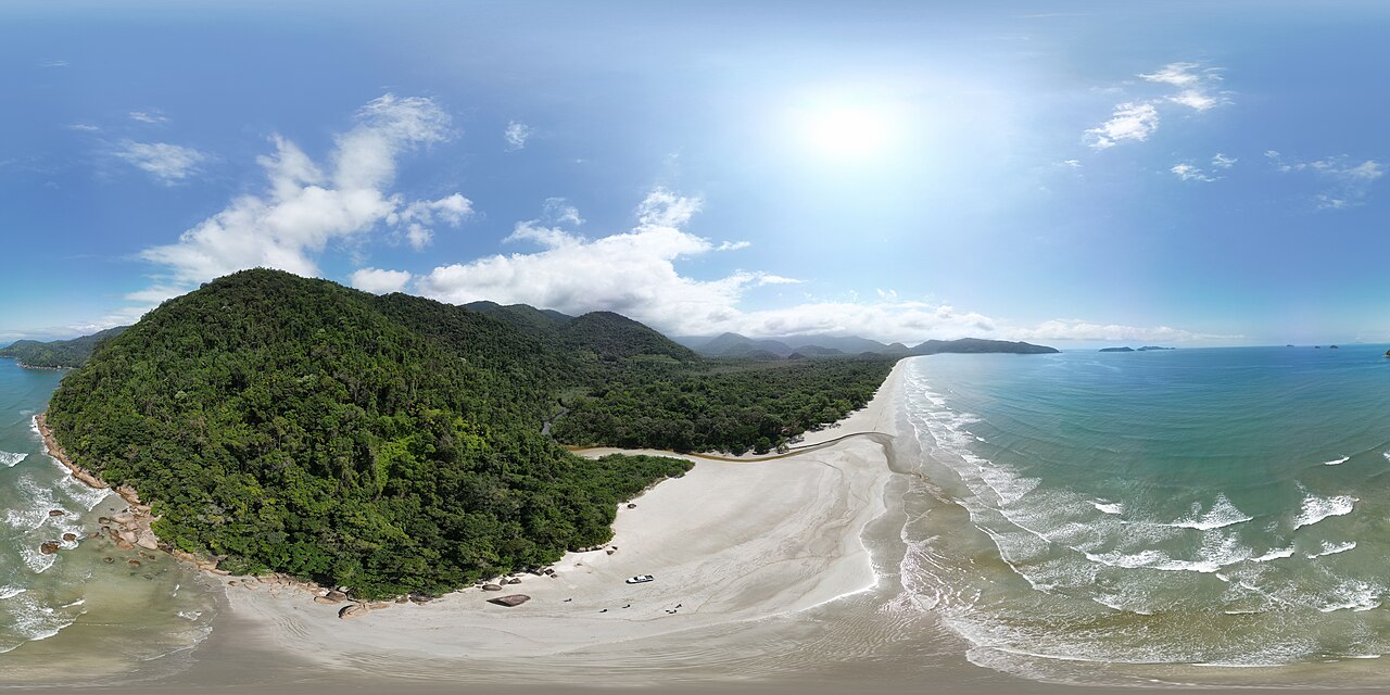 Praia da Fazenda vista do alto, com morros de mata ao fundo.