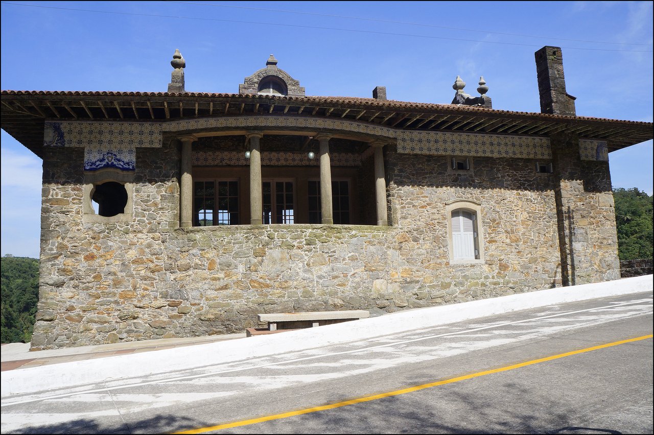 Fachada de pedra do Pouso de Paranapiacaba, com varanda de colunas e telhado cerâmico, à beira da estrada